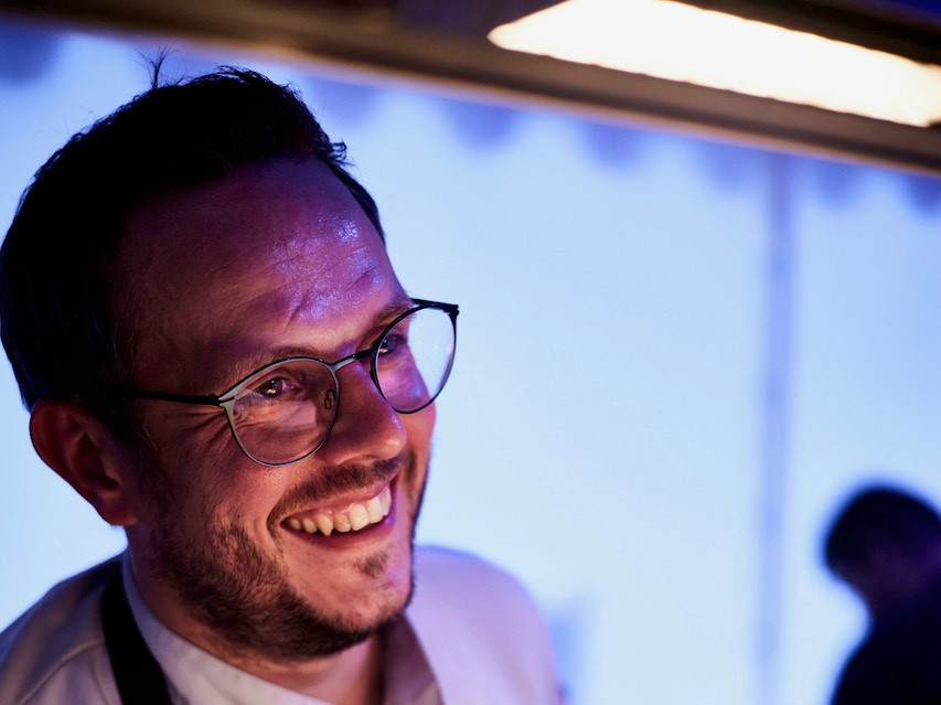 Benjamin Kehl leitet das Landhaus Kehl Ein Mann mit Brille lächelt ein Tellergericht an.